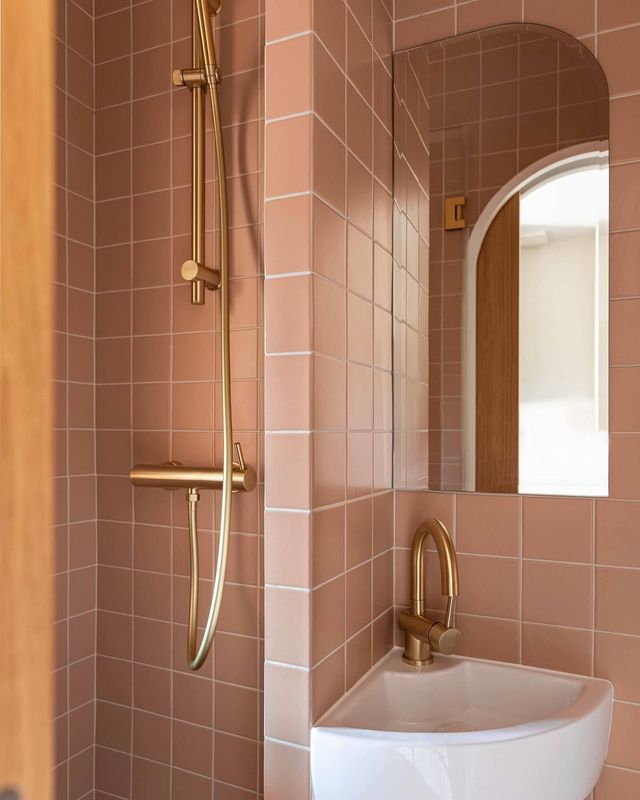 Grâce à des courbes et de la robinetterie en laiton, la sensation d'espace est décuplée dans cette mini salle de bains.